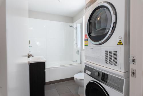 a bathroom with a toilet and a washing machine at Paihia 2 Bedroom Apartment with Pool in Paihia