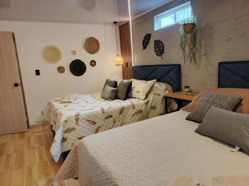 a bedroom with two beds and a table and a window at Hope Aparta Lofts in Salento