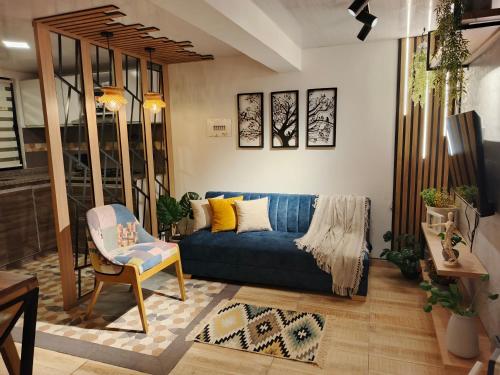 a living room with a blue couch and a chair at Hope Aparta Lofts in Salento