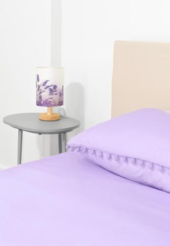 a bedroom with a bed and a table with a lamp at Purple Serenity at Brooklyn in Brooklyn