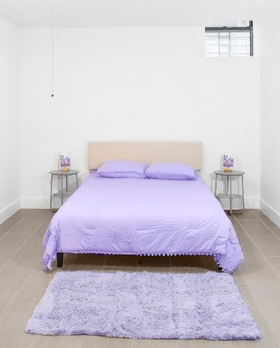 a bedroom with a purple bed with two tables at Purple Serenity at Brooklyn in Brooklyn