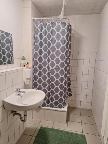 een badkamer met een wastafel en een douchegordijn bij Gästezimmer 2 in Mönchengladbach