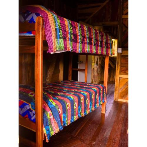ハルディンにあるhospedaje rural finca cafetera La Malokaのベッド(カラフルな毛布付)