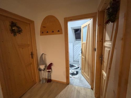 un pasillo con una puerta abierta con una tabla de surf en la pared en Domek u Jarząbków, en Ciche