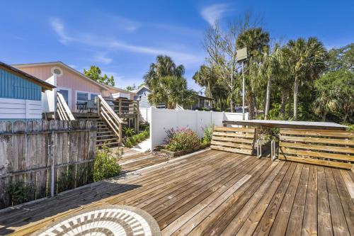a backyard with a wooden deck and a fence at The Pink House in Cedar Key