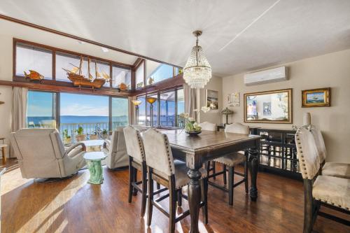 a dining room with a table and chairs and a large window at Cedar Tides in Cedar Key