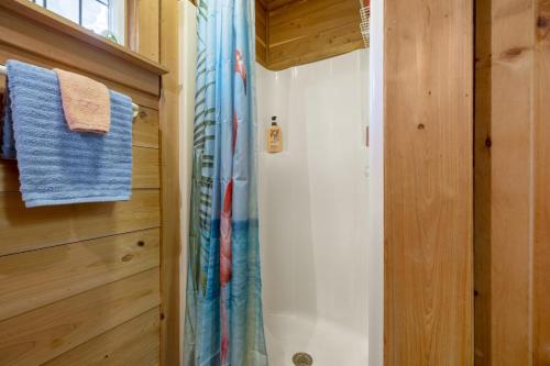 a bathroom with a shower with a blue shower curtain at Cedar Hill Depot in Cedar Key