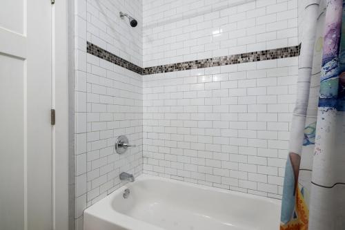 a white bath tub in a bathroom with white tiles at Beach Shack in Cedar Key