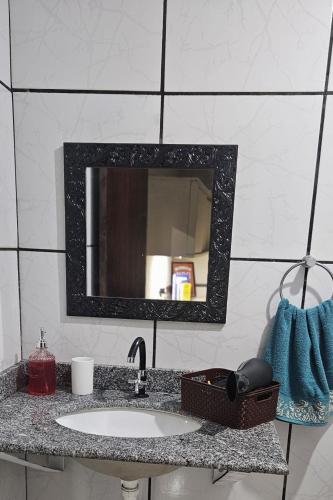 a bathroom counter with a sink and a mirror at Casa Canto do Farol in Navegantes