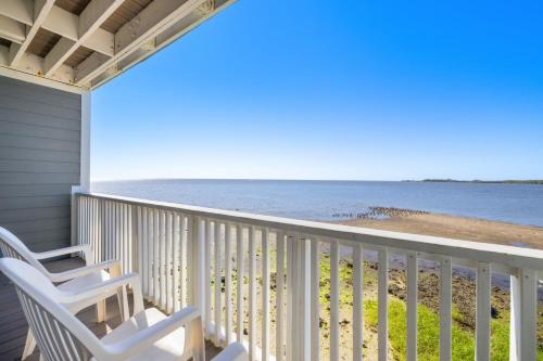 a balcony with two chairs and the ocean at Sunset Harbor 7 in Cedar Key