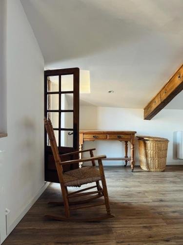 a wooden chair sitting in a room with a table at Remparts House in Mailhac