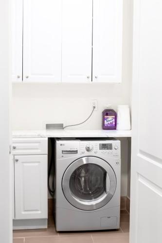 a white laundry room with a washing machine at Blue Ocean Escape in Brooklyn in Brooklyn