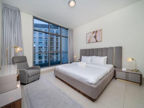 a bedroom with a bed and a large window at Tranquil 1 Bedroom Dubai Hills Escape in Dubai