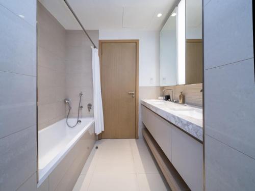 a bathroom with two sinks and a bath tub at Tranquil 1 Bedroom Dubai Hills Escape in Dubai