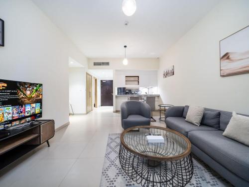 a living room with a couch and a table at Tranquil 1 Bedroom Dubai Hills Escape in Dubai