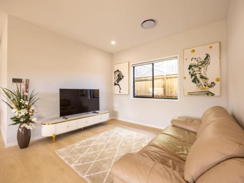 a living room with a couch and a flat screen tv at Luxurious 4 Bedroom Home with AC, Wi-Fi and SmartTV in Park Ridge