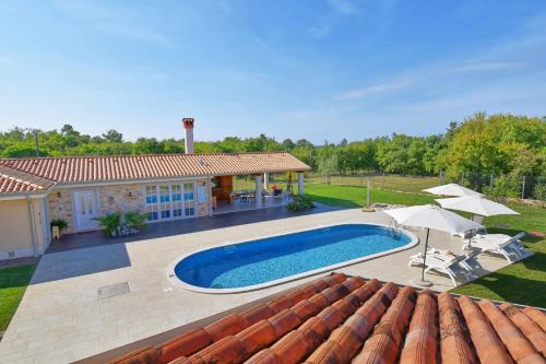 Un patio trasero con piscina y una casa. en Villa Manuela by Rent Istria, en Babići