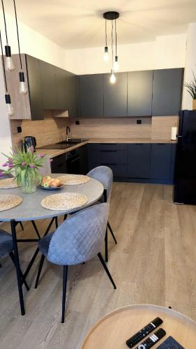 a kitchen with two tables and chairs and a sink at Apartament Stary Tartak in Ostróda