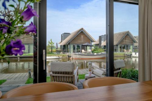 a dining room with a view of the water at Aan Het Water 'Wetterhaghe' optioneel met E-Sloep in Heeg