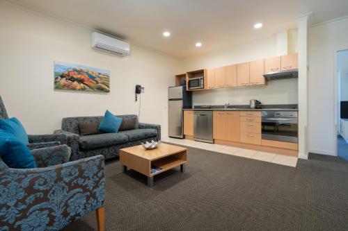 a living room with a couch and a table at Regal Palms Resort in Rotorua