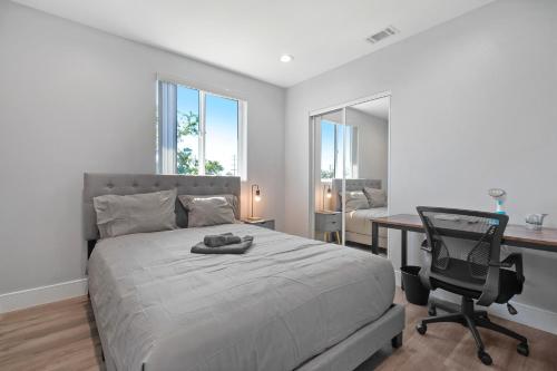 ロサンゼルスにあるModern Bedroomのベッドと机と椅子のある寝室