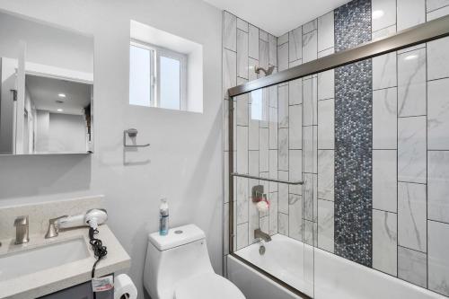 ロサンゼルスにあるModern Bedroomのトイレとガラスのシャワー付きのバスルーム