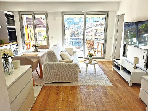 un soggiorno con mobili bianchi e ampie finestre di Superbe Appartement Luxueux Spacieux 50 m2 Port Nice a Nizza