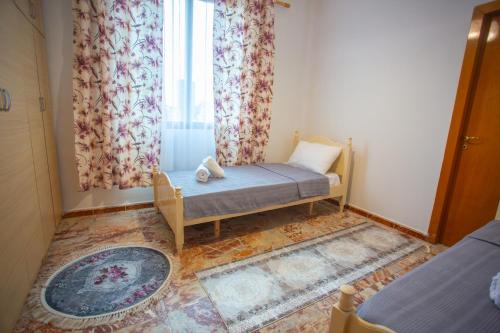 una piccola stanza con un letto e una finestra di Klevi Apartment a Tirana