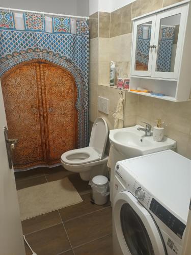 a bathroom with a toilet and a washing machine in it at Penzion mezi zámky in Kostelec nad Orlicí