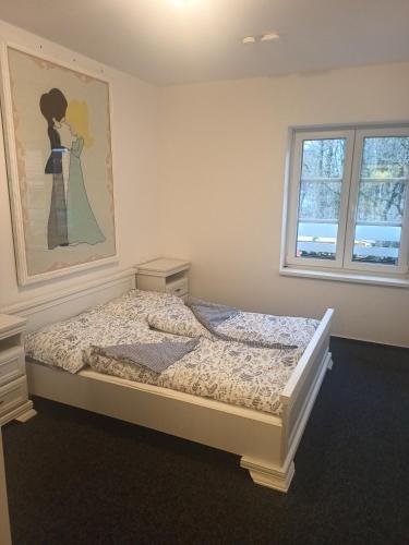 a bedroom with a bed with a painting on the wall at Penzion mezi zámky in Kostelec nad Orlicí