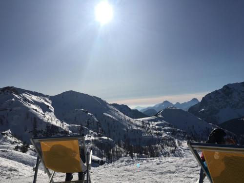 a view of a snow covered mountain with two chairs at Ruheoase zwischen Bergen und Seen mit Infrarotsauna in Hermagor