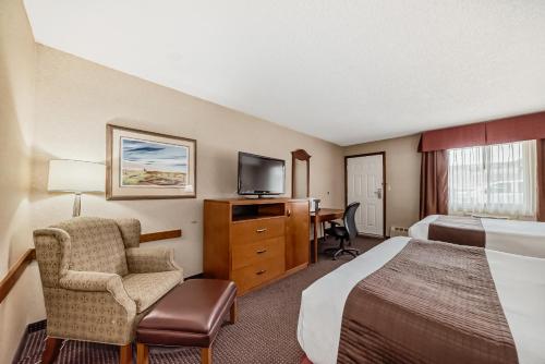 Postel nebo postele na pokoji v ubytování Stony Plain Inn & Suites