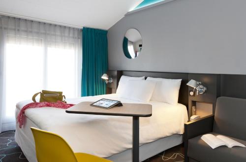 A bed or beds in a room at ibis Styles Roanne Centre Gare