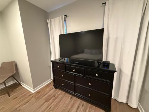 a black dresser with a tv on top of it at Central to Zoo and Baxter Arena, Pet Friendly in Omaha