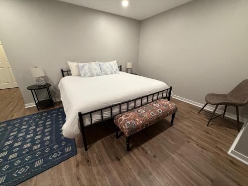 a bedroom with a large bed and a chair at Central to Zoo and Baxter Arena, Pet Friendly in Omaha