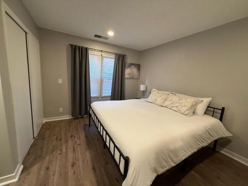 a bedroom with a large white bed with a window at Central to Zoo and Baxter Arena, Pet Friendly in Omaha