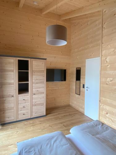 a bedroom with wooden walls and a bed and a lamp at Ruheoase zwischen Bergen und Seen mit Infrarotsauna in Hermagor