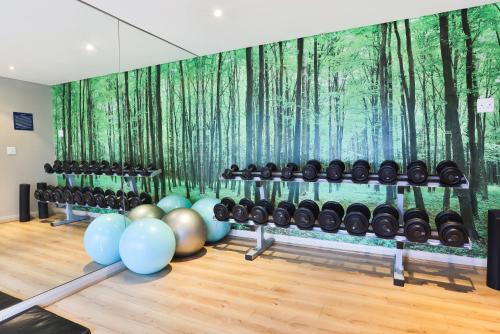 a room with a wall with a painting of trees at Holiday Inn Express Cape Town City Centre by IHG in Cape Town