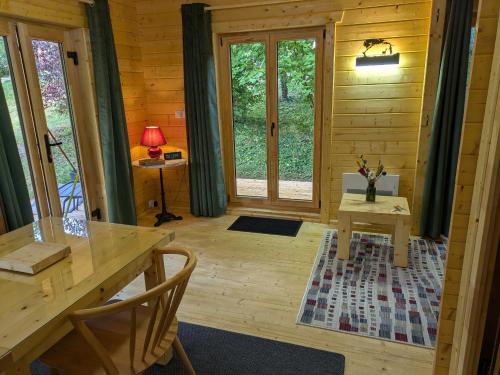 a dining room in a log cabin with a table and chairs at Havre champêtre, maison et chalet in Guerville