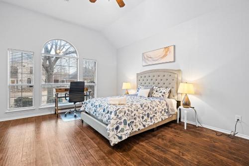 a bedroom with a bed and a desk and windows at Game Room, Crib, Fenced Backyard, Relocation Stay in Frisco