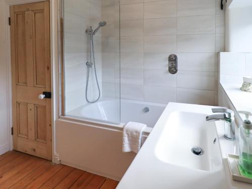 ein Badezimmer mit Dusche, Waschbecken und Badewanne in der Unterkunft Daisy Cottage in Grasmere
