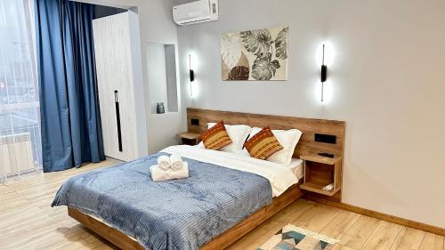 Un dormitorio con una cama con una manta azul. en Новая студия в самом центре города, en Almaty