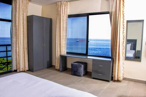 a bedroom with a bed and a large window at Venue 360 in Freetown