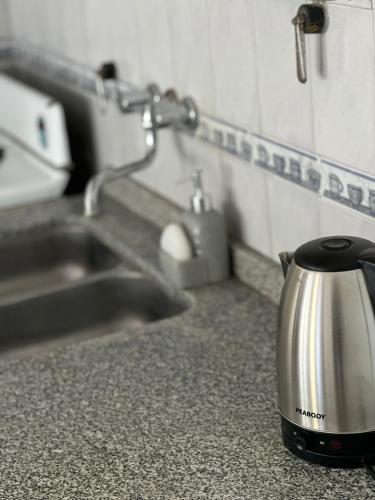 ein Teekessel auf einer Theke neben einem Waschbecken in der Unterkunft Lo de Nina in Villa María