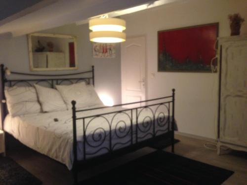 een slaapkamer met een bed met witte kussens bij Le Verger de Sauvebonne in Hyères