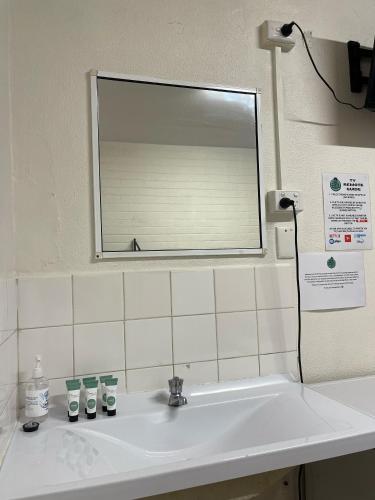 a bathroom sink with a mirror above it at Youth Shack Backpackers Darwin in Darwin