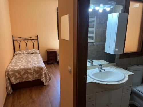 a bathroom with a sink and a bed at MIRADOR DE PEGUERINOS in Peguerinos
