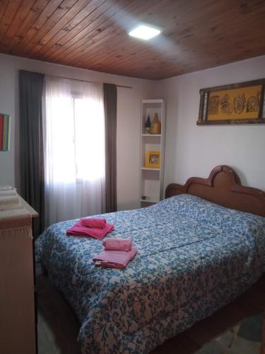 a bedroom with a bed with two pink towels on it at La Cabaña hospedaje in Tilcara