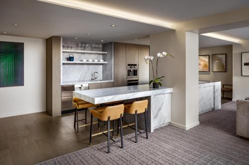 a kitchen with a counter and stools in a room at Fairmont Century Plaza Los Angeles at Beverly Hills in Los Angeles