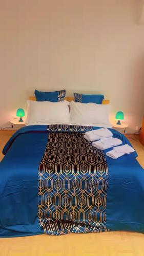 - un lit avec une couette bleue dans une chambre dans l'établissement Nid douillet Chalon Centre Grand Confort, à Chalon-sur-Saône